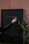 Eine Hand die goodbye auf eine Tafel schreibt